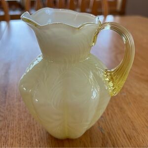 Vintage Fenton Buttercup yellow over white glass pitcher with a fern pattern.